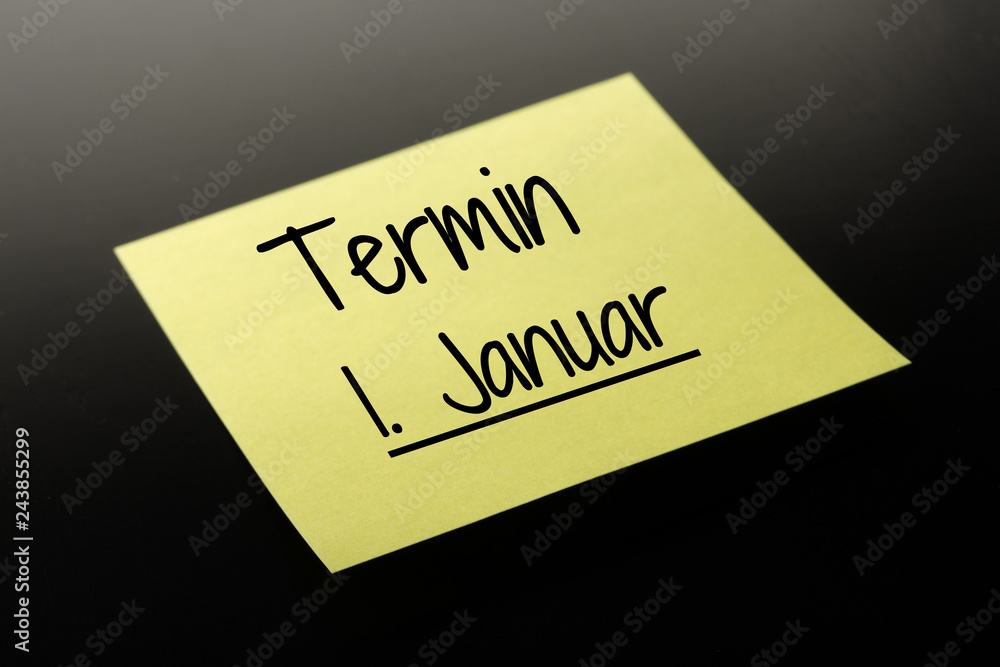 Termin 1. Januar - gelber Notizzettel dunkler Hintergrund Termin 1. Januar - gelber Notizzettel dunkler Hintergrund