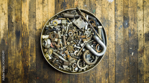 Mix of rusty auto scrap including nuts, bolts, springs, washers, cotter pins, collected in the old metallic can.