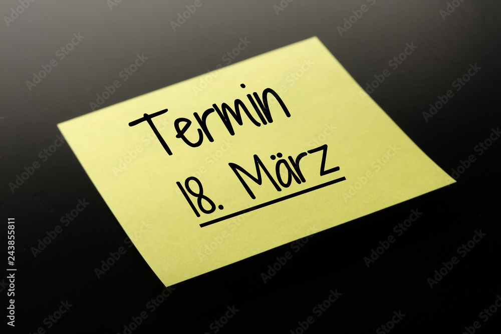 Termin 18. März - gelber Notizzettel dunkler Hintergrund Termin 18. März - gelber Notizzettel dunkler Hintergrund