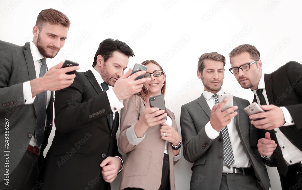 business team looking at the screens of their smartphones business team looking at the screens of their smartphones