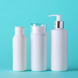 White cosmetic tubes on blue background with copy space. Skin care, body treatment, beauty concept. Square crop