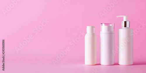 White cosmetic tubes on pink background with copy space. Skin care, body treatment, beauty concept