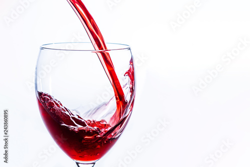 Close up of Red Wine Pouring Into Glass on light background, Alcohol abuse and alcoholism, celebration and party concept. With copy space.