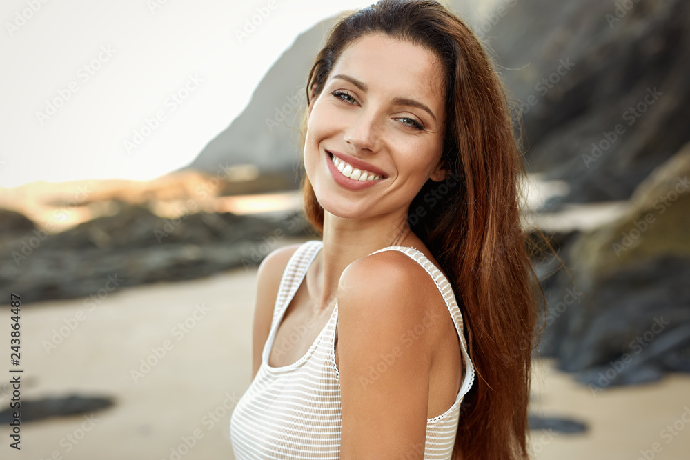 Fototapeta premium Piękna uśmiechnięta kobieta spędza czas na plaży