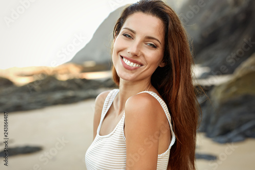Beautiful smiling woman spends time on the beach