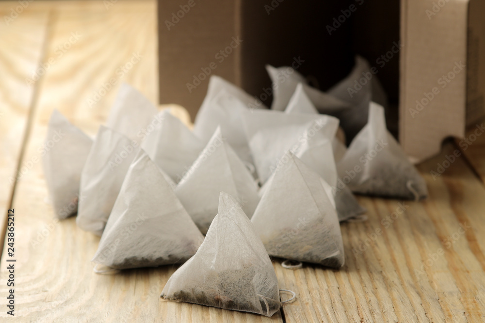 tea bags pyramid fall out of the box close-up on a natural wooden table tea bags pyramid fall out of the box close-up on a natural wooden table