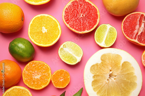 Different citrus fruits on color background  top view