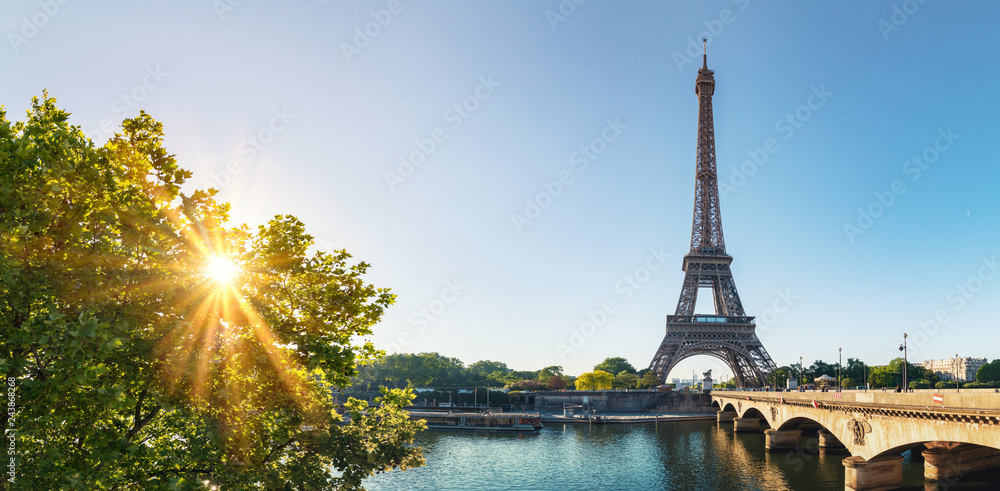 Naklejka premium Paryska ulica z widokiem na sławną Paryż wieżę eifla w słonecznym dniu z niektóre światłem słonecznym