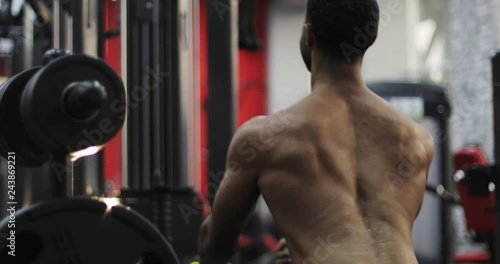 Close-up muscular back of a black male exercising in the gym. photo