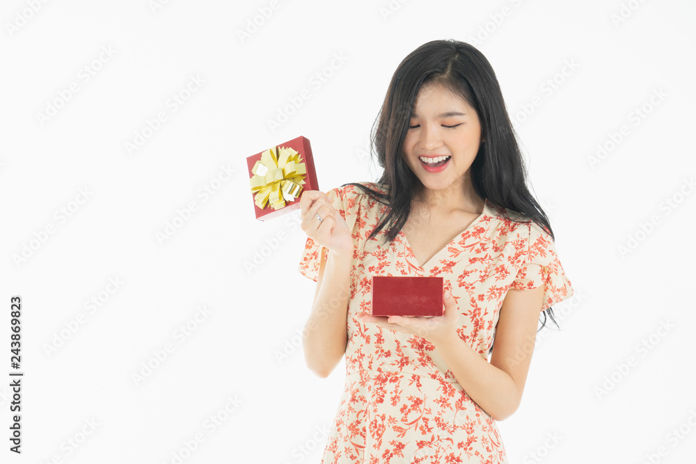 asian curious woman in red dress rejoicing her birthday or new year gift box. Young woman holding gift box with red bow being excited and surprised holiday present isolated white background asian curious woman in red dress rejoicing her birthday or new year gift box. Young woman holding gift box with red bow being excited and surprised holiday present isolated white background