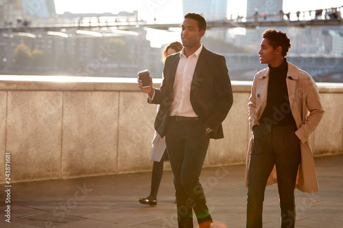 Canvas Print Two business colleagues walking by the Thames riverside in the city of London ta