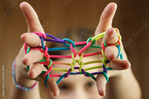 Girl playing classic string game, creating shapes photo