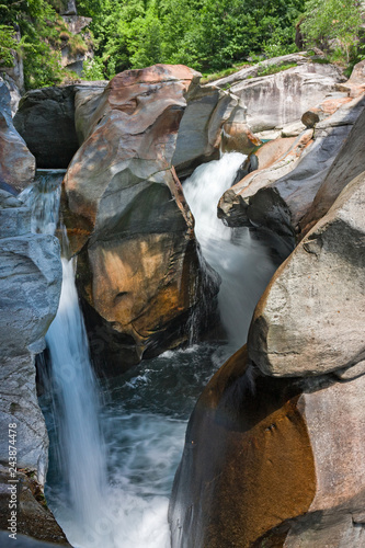 Water cascade of the river Toce among the rocks smoothed in the gorges of the ravines of Uriezzo in val Antigorio, in Piedmont, Italy. photo