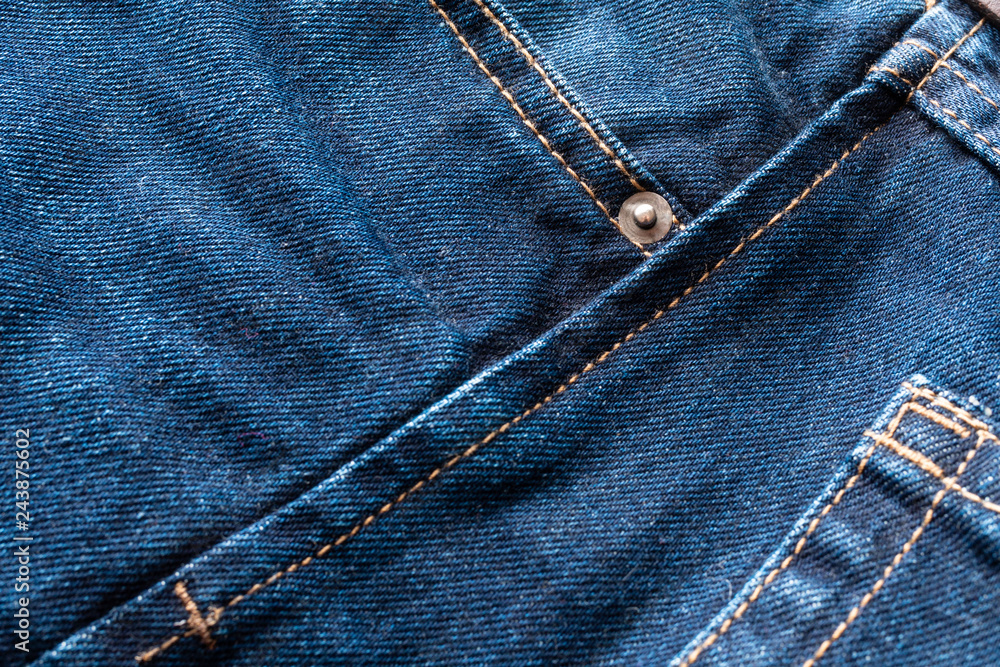 Fototapeta premium Blue jeans fabric macro seam pattern blurred background