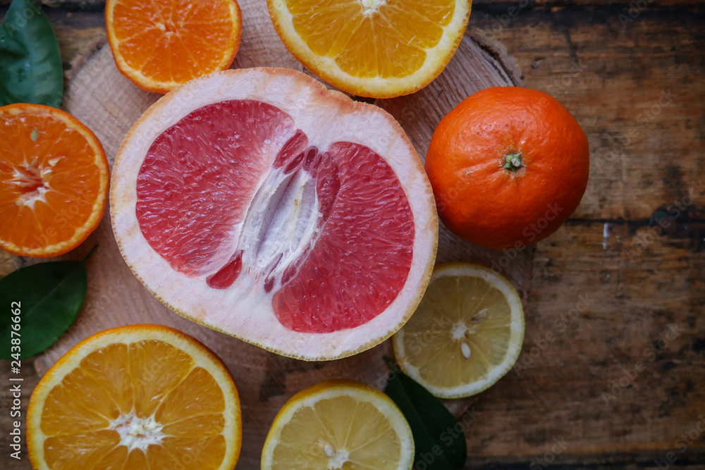 Grapefruits, oranges, tangerines, lemons, sliced on a wooden saw Grapefruits, oranges, tangerines, lemons, sliced on a wooden saw