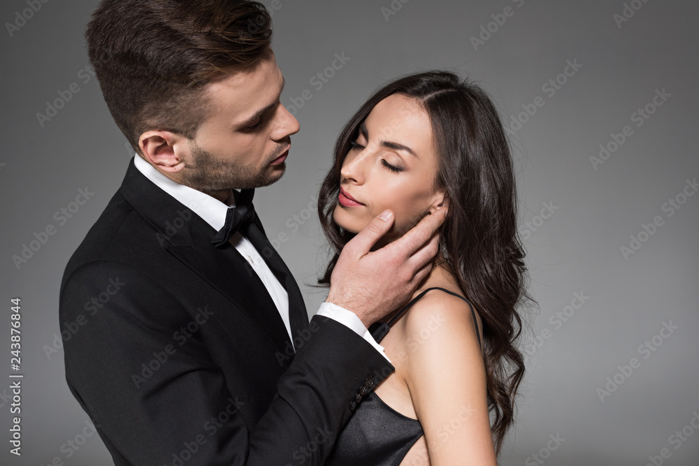 attractive elegant couple in black clothes hugging isolated on grey attractive elegant couple in black clothes hugging isolated on grey