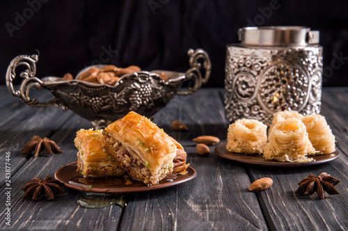 Close up. Still life. Eastern honey sweets. Turkish traditional baklava with pistachios and baklava bird's nest. Dark wooden background.