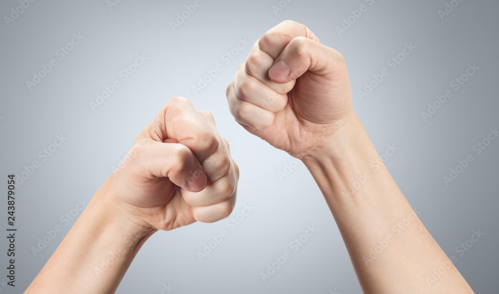 Fists in a fighting stance, ready to fight. First person view on gray background Fists in a fighting stance, ready to fight. First person view on gray background