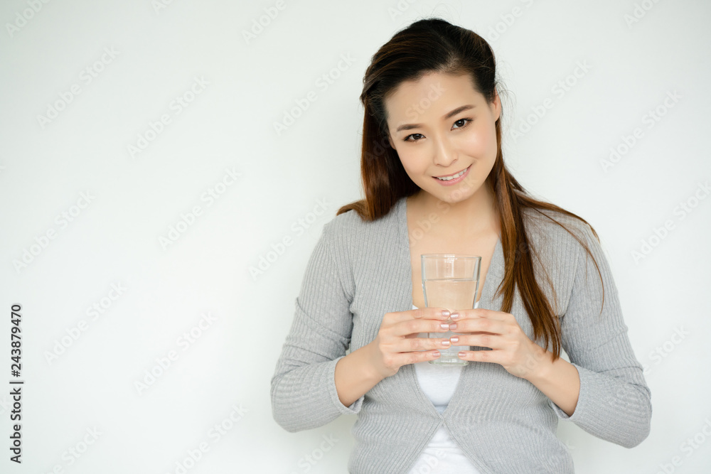 Asian Women hand is holding glass of water with pure water. Drinking of clean water and the temperature of 6-8 glasses per day will make skin of the body not wrinkled before age. And good for health Asian Women hand is holding glass of water with pure water. Drinking of clean water and the temperature of 6-8 glasses per day will make skin of the body not wrinkled before age. And good for health