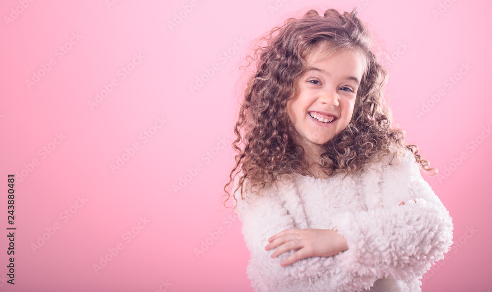 Portrait of a little curly girl on a pink background Portrait of a little curly girl on a pink background