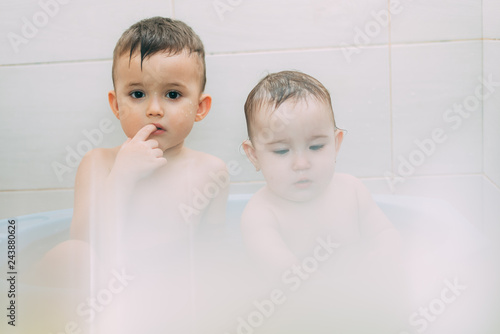 children, brother and sister in the bathroom swimming, playing splashing photo