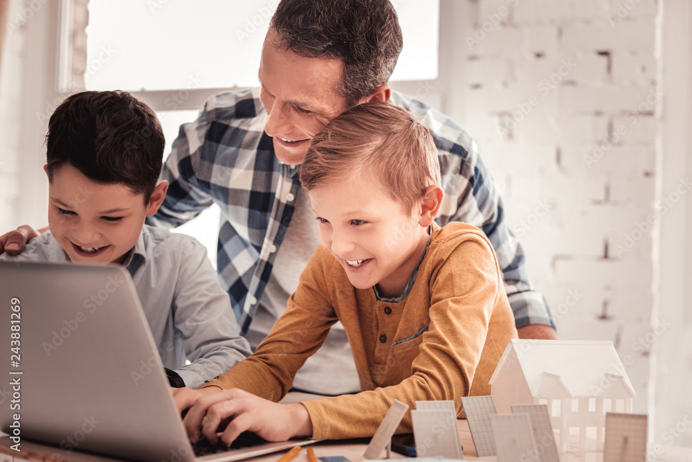 Father and sons feeling joyful watching video about waste sorting Father and sons feeling joyful watching video about waste sorting