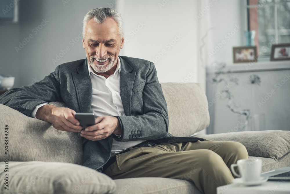 Smiling man feeling lovely reading messages from wife