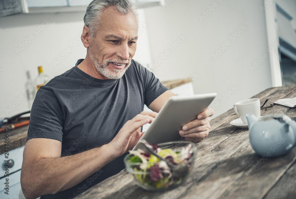 Contended man reading article on tablet