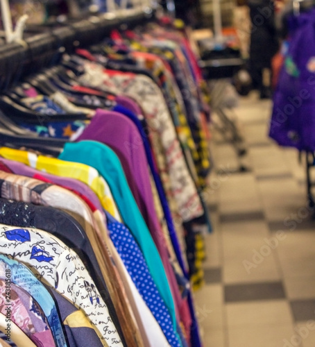 Women's clothes hanging on hangers in a fashion salon