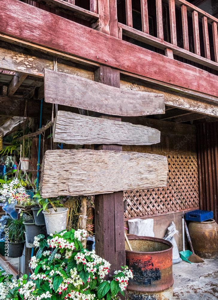 Weathered wooden signboard with flower decoration in rural