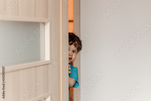 Принти на полотні little kid hiding behind the door playing hide and seek