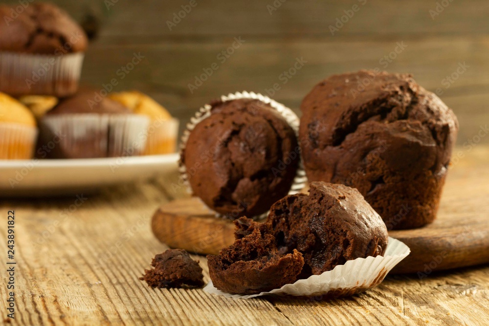 Chocolate muffin, homemade pastry on a wooden background close-up in rustic style Chocolate muffin, homemade pastry on a wooden background close-up in rustic style