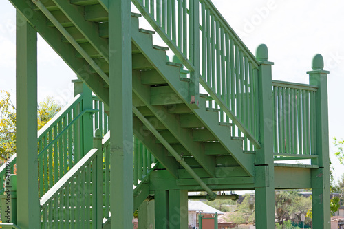 Green painted wooden staircase at the outside corner of a building
