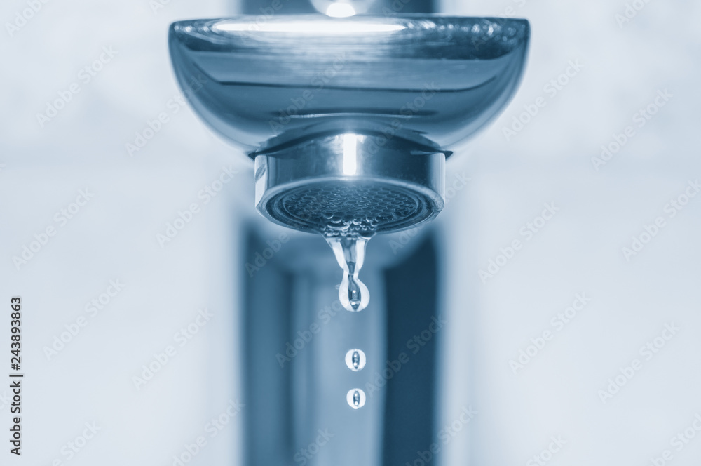 Faucet and drops close up on blue background Faucet and drops close up on blue background