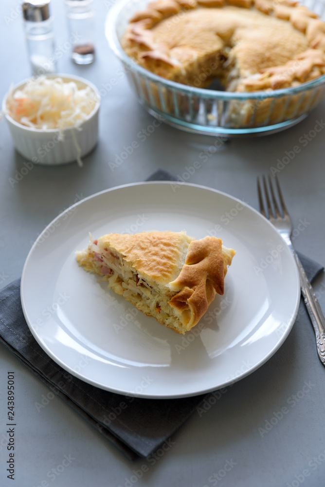Slice of homemade sauerkraut pie on gray wooden table. Cabbage cake tradition russian food Slice of homemade sauerkraut pie on gray wooden table. Cabbage cake tradition russian food