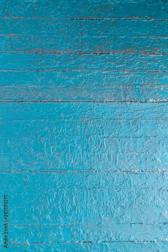 Grungy multi layered peeling paint on wooden planks background or texture in blue.