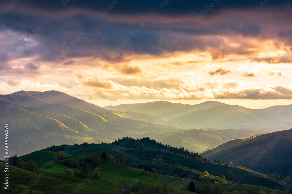 wonderful countryside in springtime at sunset. gorgeous cloudscape above the the rolling hills in rural area. fantastic view from above. distant valley in haze and evening light.