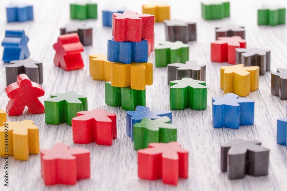 White wooden figure in the shape of a man stands on other details. Parts of the board game. White wooden figure in the shape of a man stands on other details. Parts of the board game.