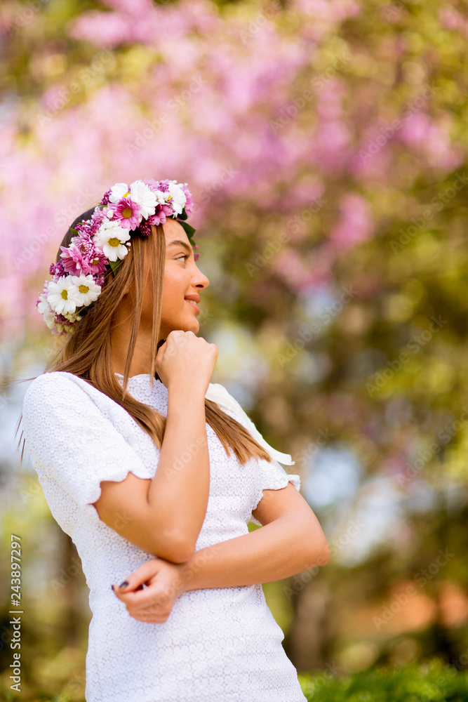 Portrait of young woman with wreath of fresh flowers on head Portrait of young woman with wreath of fresh flowers on head