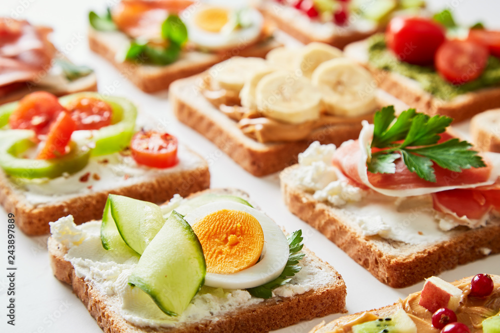 Sandwiches variation with vegetables, fruits, meat, eggs and sweets viewed from above. Variety of bruchetta breads arranged for a tasty and healthy breakfast. 