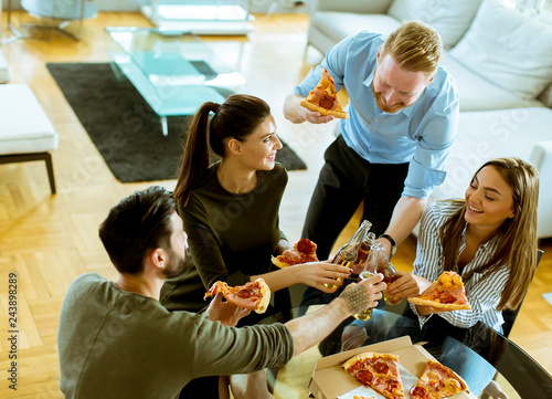 Young people eating pizza a...