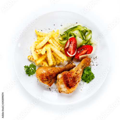 Drumsticks with french fries and vegetable on white background