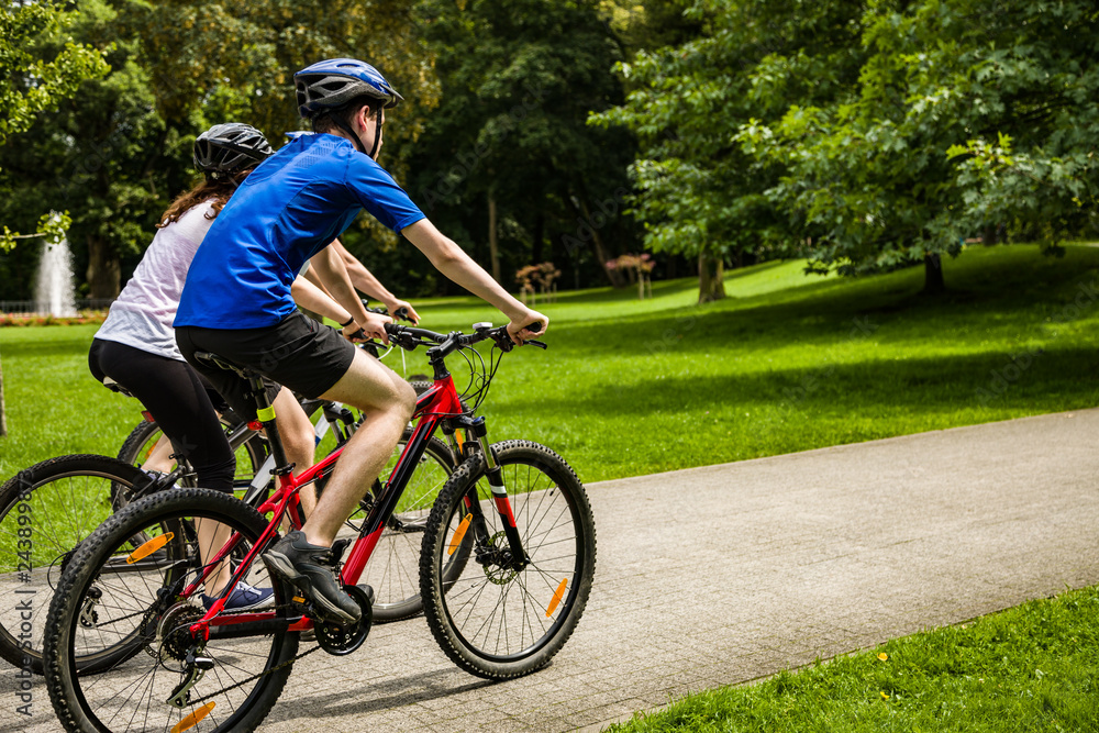 Healthy lifestyle - people riding bicycles in city park Healthy lifestyle - people riding bicycles in city park