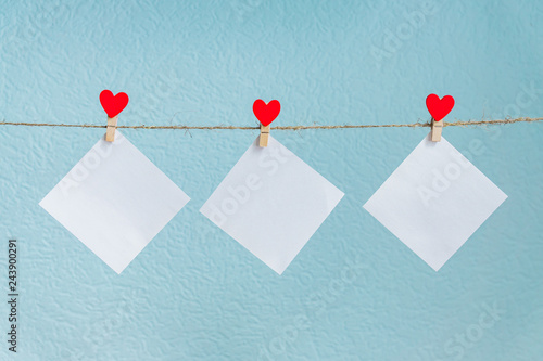 Blank cards on pins with red hearts. Mockup for text and blue background for Valentines Day greetings