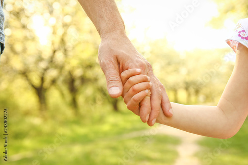 the parent holding the child's hand with a happy background © Kostia