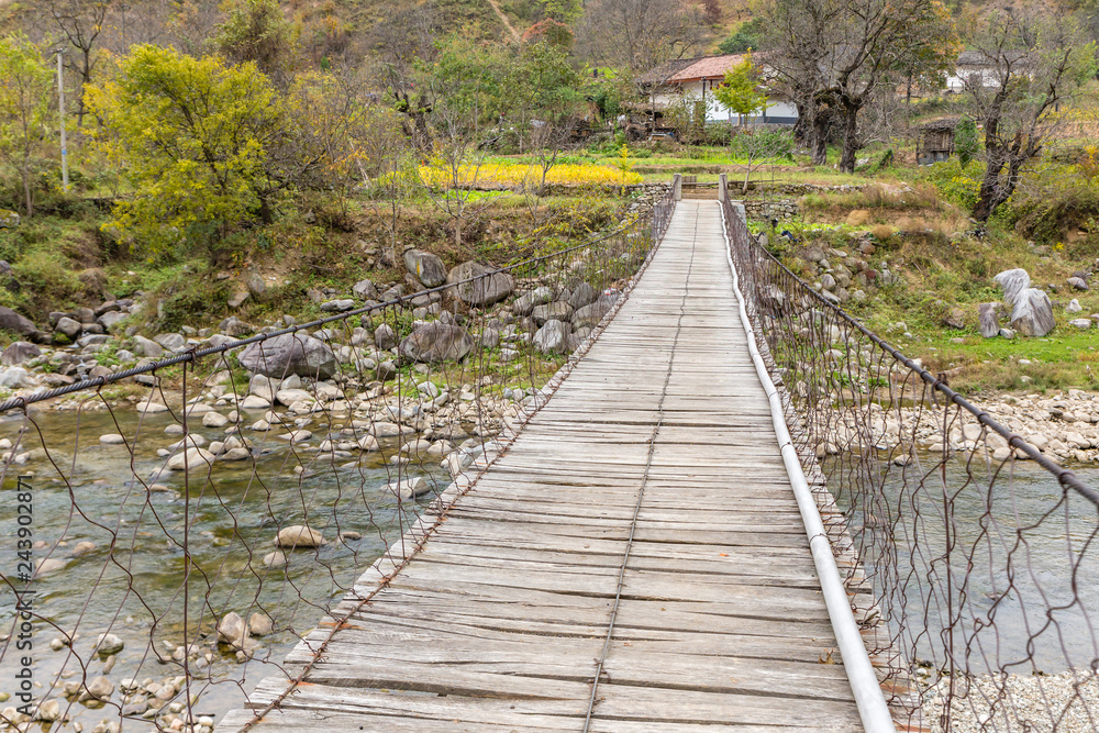 Obraz premium wooden suspension bridge over a river in the mountains, China Shaanxi Province