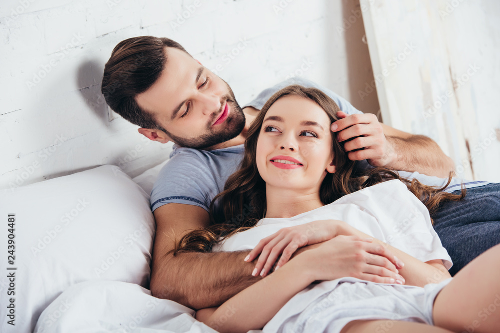 adult loving couple gentle hugging in bedroom while man touching hair of  woman Stock Photo | Adobe Stock
