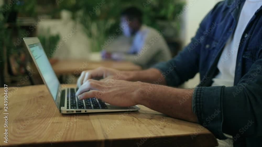 Cropped view of freelancer using laptop in cafe. Close-up partial view of male hands typing on laptop computer keyboard in coffee shop. Freelance concept Cropped view of freelancer using laptop in cafe. Close-up partial view of male hands typing on laptop computer keyboard in coffee shop. Freelance concept