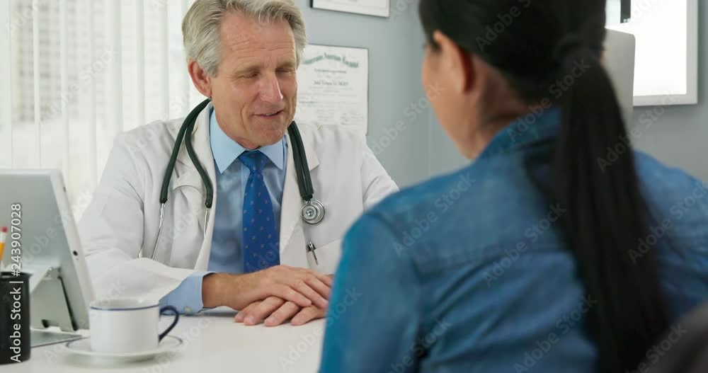 Camera pushing in on doctor talking to patient in hospital office Camera pushing in on doctor talking to patient in hospital office