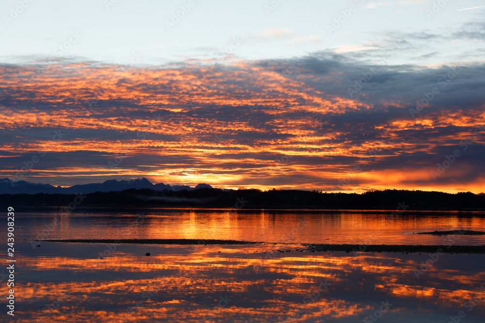 orange sunset at lake chiemsee with dramatic clouds